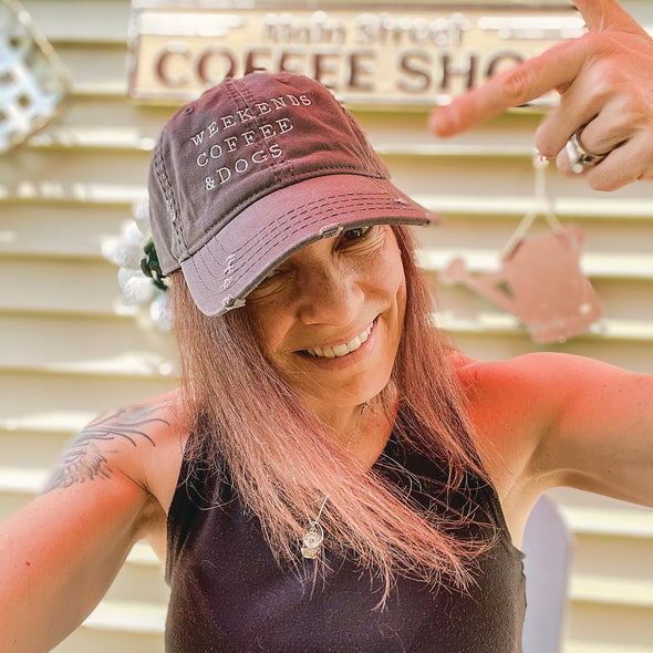 woman wearing weekends, coffee & dogs distressed baseball hat